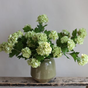 Light green faux snowball flower branch with realistic textured blooms, for DIY floral decor