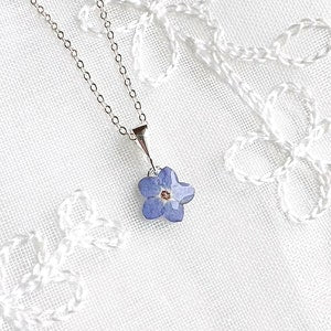 Sterling silver necklace with tiny blue pressed flower pendant on chain