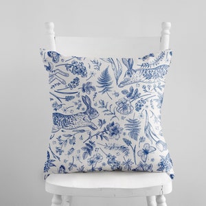 Blue and white spring floral and bunny print pillow cover with decorative trim