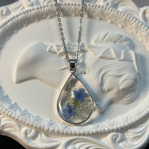 Teardrop pressed flower necklace with blue forget-me-not pendant on silver chain