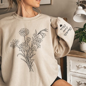 Cream sweatshirt with hand-drawn floral bouquet graphic on the front