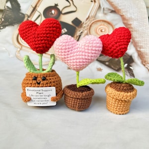Handmade crochet heart plant pot with red and pink crocheted hearts and two small pots