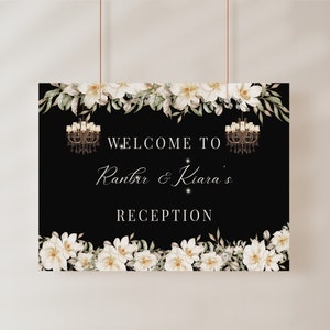 Wedding reception sign with black background, white floral garland, chandelier motifs, welcome text