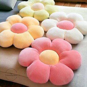Colorful flower-shaped throw cushion pillow with soft pink, peach, and white petals