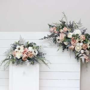Boho floral arch arrangement with blush pink, beige, and white flowers plus greenery