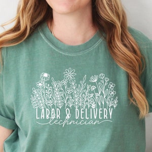 Green crew-neck t-shirt with white 'Labor & Delivery Technician' floral graphic