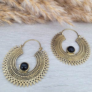 Gold-tone hoop earrings with ornate mandala edging and dark round cabochon stones