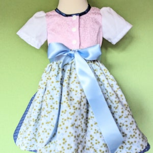 Baby dirndl dress with pink bodice, puff sleeves, floral skirt and blue ribbon sash