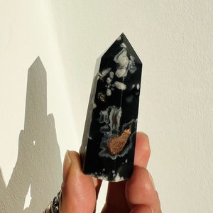 Black flower agate crystal obelisk with white and peach inclusions