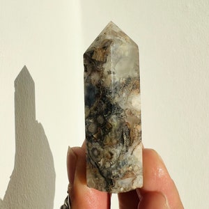 Black flower agate crystal obelisk point with clear quartz veining, faceted tower