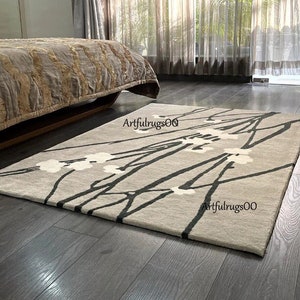 Cream wool area rug with dark abstract branch pattern, rectangular