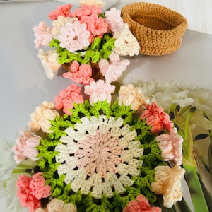 Handmade crocheted floral round coaster with pink, green, and white flower pattern