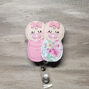 Pink plush baby swaddle blanket with animal-face trim and floral details