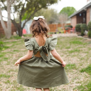 Olive green linen flutter-sleeve dress, back view with gathered skirt