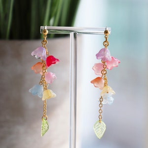Pastel flower dangle earrings with gold-tone hooks and multi-color leaf charms