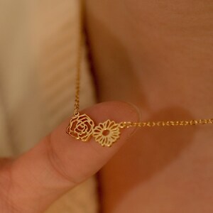 Gold birth-flower necklace with multiple small floral charms on a delicate chain