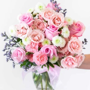 Pink rose and carnation fresh flower bouquet with white filler flowers, wrapped in white ribbon