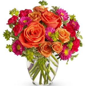 Orange and pink rose bouquet with purple blooms in clear glass vase