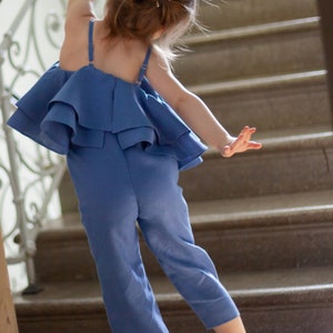 Dusty blue girls’ overall dress with off-shoulder ruffled neckline and wide-leg fit