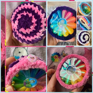 Pink fuzzy round case with circular screen window and decorative multicolor flower design