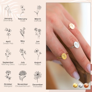 Gold-tone birth month flower charm ring with engraved text, worn on finger