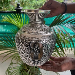 Engraved metal Radha-Krishna flower vase with floral patterns and relief figure