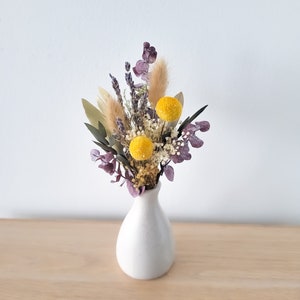 Mini dried floral bouquet with yellow and purple flowers in a small white vase