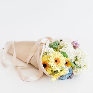 Beige canvas lay-flat flower tote with bouquet inside