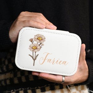 White faux-leather birth flower jewelry box with stitched border and floral name graphic