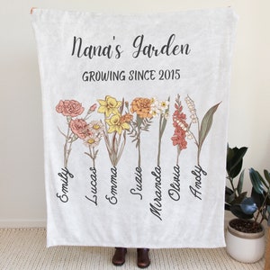 White throw blanket with floral artwork and 'Nana's Garden' text