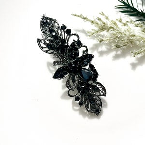 Black rhinestone flower hair clip with layered petals and leaf details