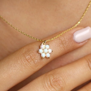 Dainty opal flower pendant necklace with small white opal petals on a gold chain