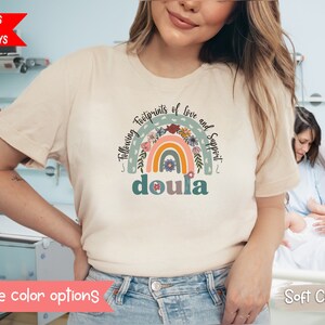 Beige short-sleeve crewneck doula T-shirt with rainbow “doula” graphic