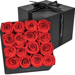 Black gift box with red preserved roses arranged in a square bouquet
