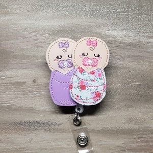 Purple and floral baby blanket key fob clip with two smiling bunny faces