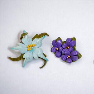 Handmade leather flower brooches, one light blue/white and one purple with pin backs