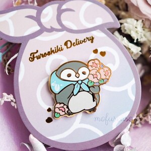 Hard enamel penguin bouquet pin with blue ribbon, on purple circular backing card