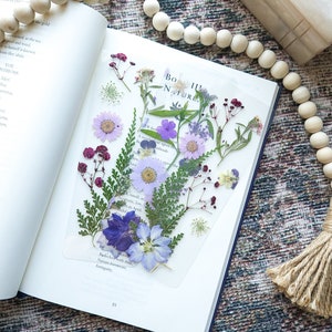 Botanical pressed flower bookmark with purple and blue blooms on white card