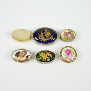 Vintage enamel pill box set with multiple round designs, decorative lids