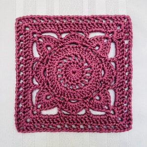 Crochet granny square motif in mauve pink with floral center and scalloped edges