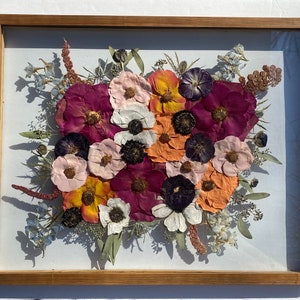Framed preserved flower arrangement with purple, pink, orange and white blooms