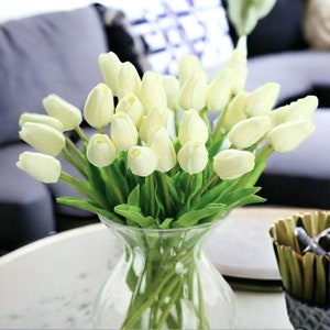 Artificial tulip centerpiece bouquet with pale white tulips in clear glass vase