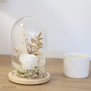 Preserved white rose in clear glass bell with gold leaves, on round base