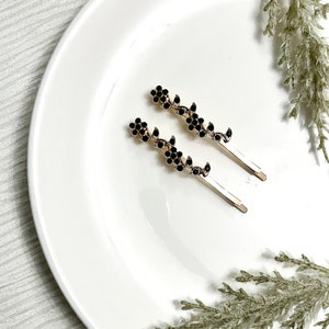 Rhinestone hair slide set with two black flower-like diamante bobby pins