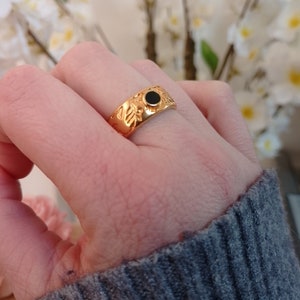 Hammered gold adjustable ring with black flower detail
