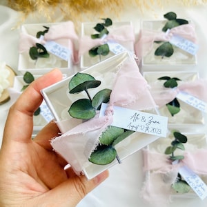 Pink tulle wedding candle favor boxes with eucalyptus leaf labels, for guest handouts