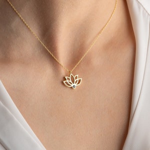 Silver lotus pendant necklace with delicate chain and small flower charm at center