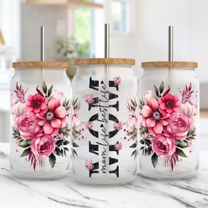 Floral glass tumblers with pink roses, black lettering, and clear lids with straws