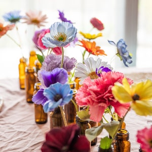 Mixed wildflower silk bud vase centerpiece with colorful blooms in small glass vases