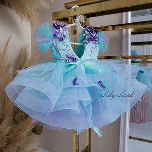 Mint blue tulle ball gown with purple bow applique and layered ruffle skirt